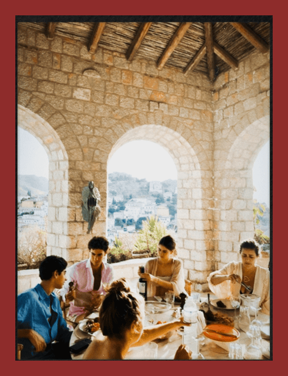 A beautiful outdoor rooftop restaurant with stone arches, offering stunning city views and a lively dining atmosphere.