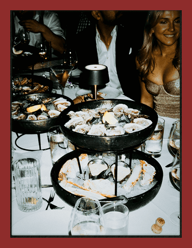 Elegant seafood platter with oysters, lemon, and garnishes on a fancy dinner table.