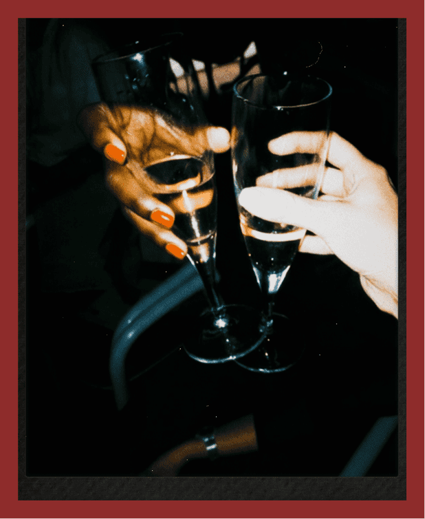 Two people clinking glasses of champagne in a celebratory moment.