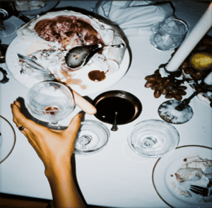 Seafood platter with oysters, fish, and grapes on a white table for a luxurious dining experience.