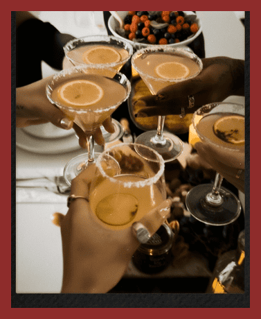 Group of friends clinking cocktails at a celebration party.
