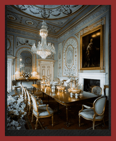 Luxurious historic dining room with ornate decor and chandelier lighting.