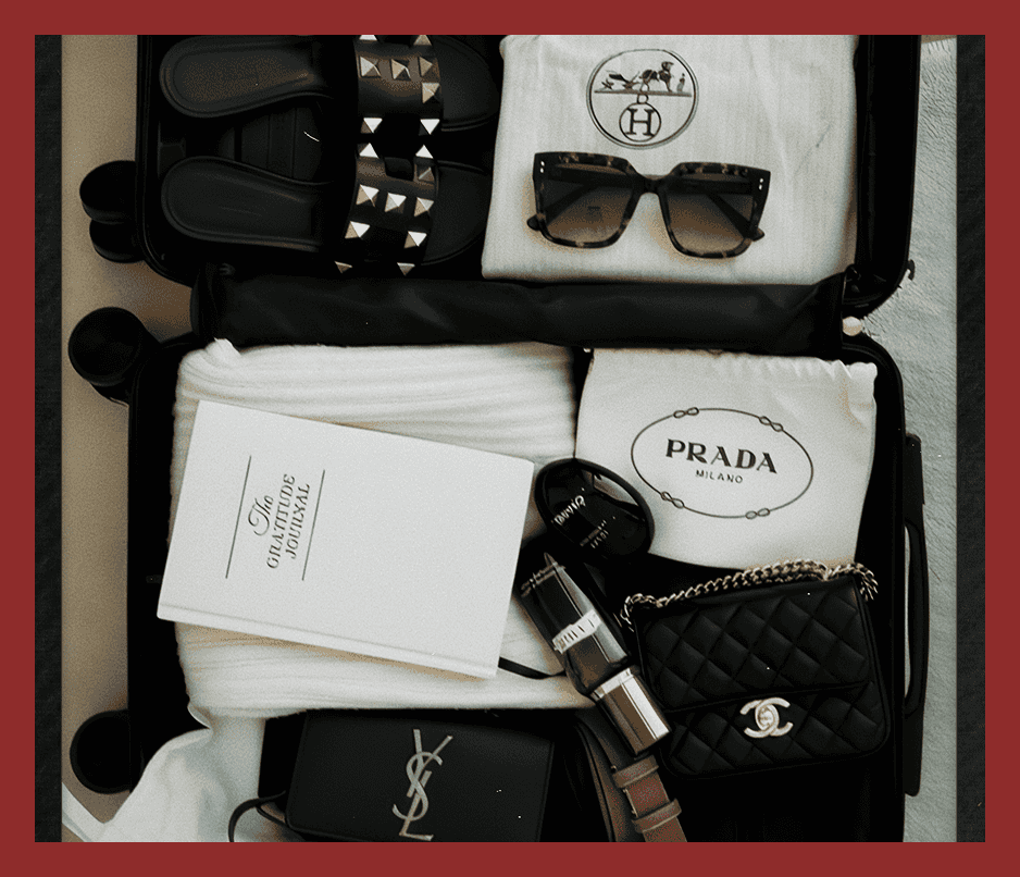 Stylish travel essentials featuring designer sunglasses, Prada and Chanel bags, and luxury accessories in a travel suitcase.
