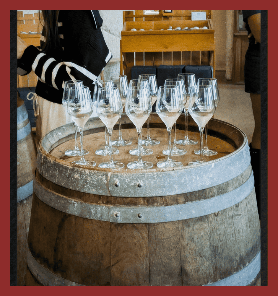 Elegant wine glasses on wine barrel at vineyard tasting event.