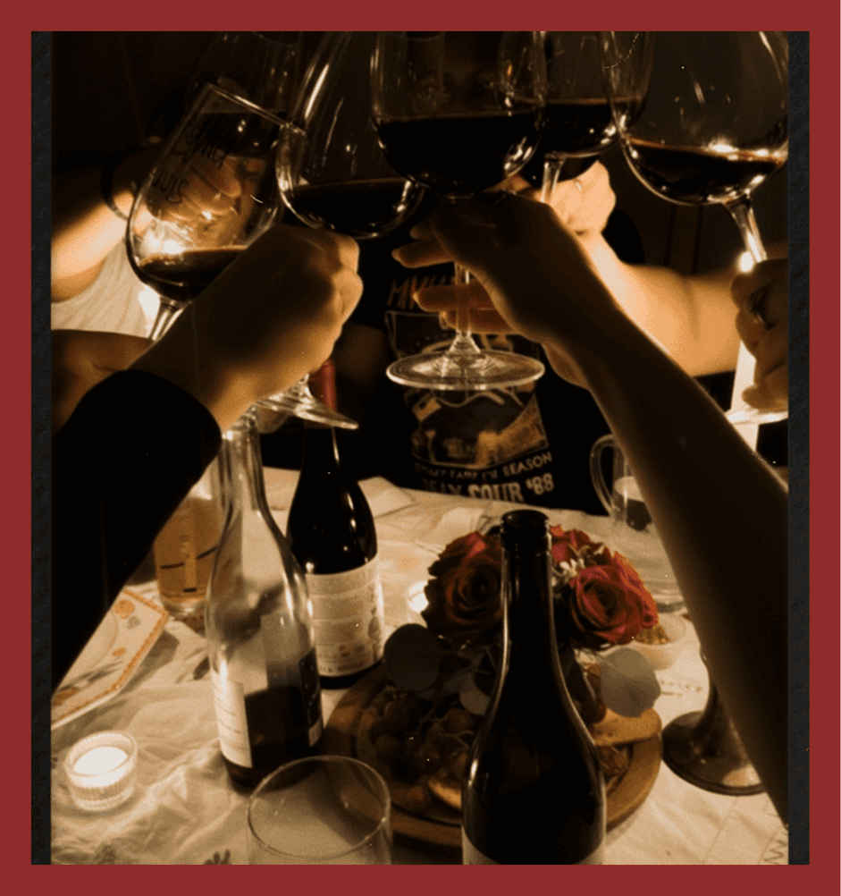 Group of friends clinking wine glasses in a celebratory toast.