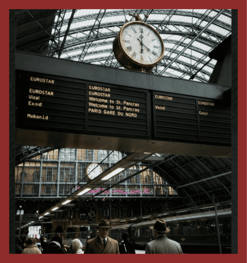 Vintage train station, departure board at London King's Cross, travelers waiting, historic railway atmosphere.